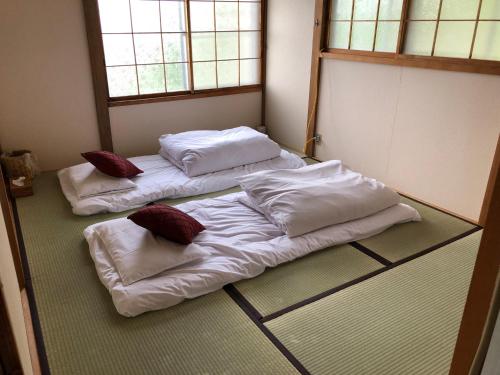 a room with two beds with pillows on the floor at Cool-Cottage Otaru OTAMOI in Otaru