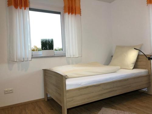 uma cama num quarto com uma janela em zollwanger - Wohnen auf Zeit em Dillingen an der Donau