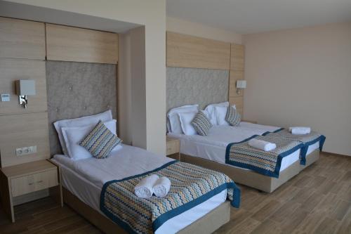 a bedroom with two beds with towels on them at Royal Grand Hotel and Spa - All Inclusive and Free beach accsess in Kavarna