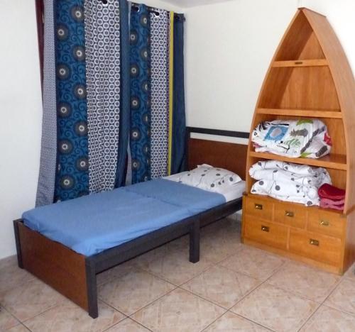 a small room with a bed and a shelf at L'Escale Royale in Salazie
