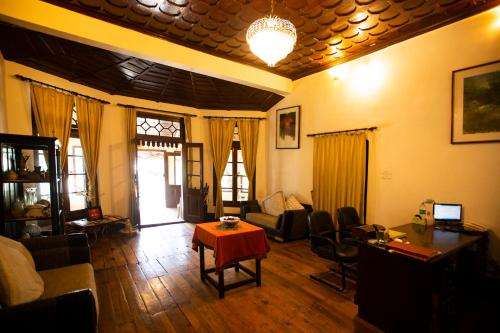 a living room with a couch and a table at The Hive Cottage By Royal Collection Hotels in Nainital