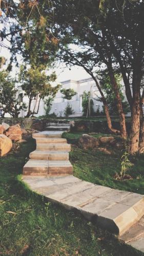 a stepping stone path in a yard with trees at Rawaat Ghaym in Taif