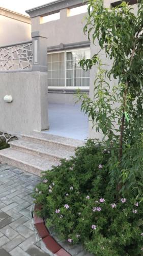 a house with stairs and flowers in a yard at Rawaat Ghaym in Taif
