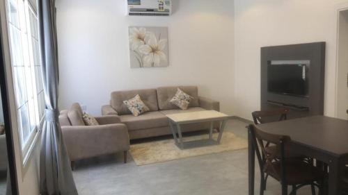 a living room with a couch and a table at Rawaat Ghaym in Taif