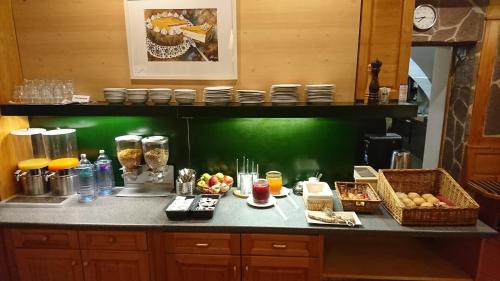 a kitchen with a counter with fruits and food on it at Hotel Vinothek Schwarzer Adler in Ottensheim