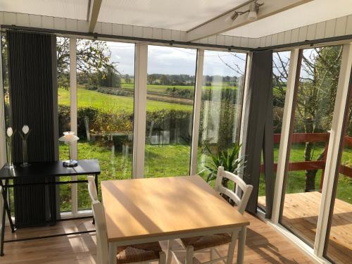 een eetkamer met een tafel en uitzicht op een veld bij Bulbrovejs Bed & Breakfast in Havdrup