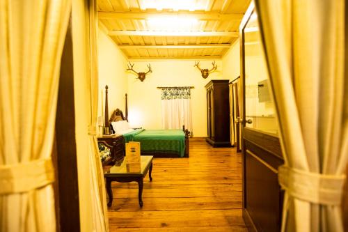a room with a bed and a room with curtains at The Hive Cottage By Royal Collection Hotels in Nainital