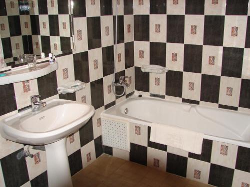 La salle de bains est pourvue d'un lavabo et d'une baignoire. dans l'établissement Hôtel Atlantique Panorama, à Safi