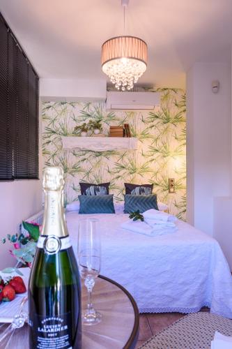 a bottle of wine on a table next to a bed at Häxaris Casa Boutique by Florentia Homes in Granada