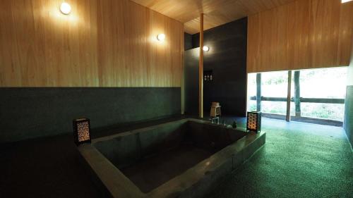a large bathroom with a large tub and a window at Setouchi Cominca Stays Hiroshima Chojaya in Shōbara