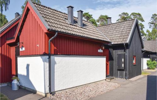 a red and black barn with a white garage door at Klitterbyn 16 in Ängelholm