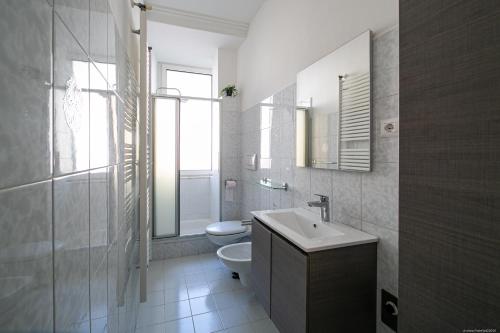 een badkamer met een toilet, een wastafel en een spiegel bij Apartment Andreas in Bolzano