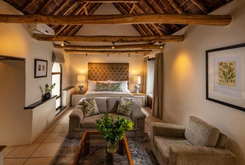 a living room filled with furniture and a large window at Grande Roche Hotel in Paarl