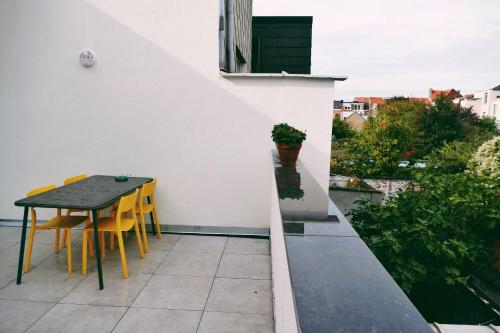 een patio met een tafel en stoelen op een balkon bij 130sqm appartment with 20sqm terras and free parking in Antwerpen
