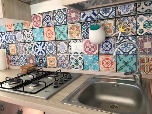 cocina con fregadero y pared de azulejos en Guendalina Mon Amour, en Roncola