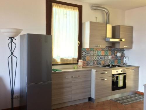 eine Küche mit einem Kühlschrank aus Edelstahl und einem Fenster in der Unterkunft Guendalina Mon Amour in Roncola