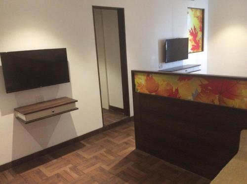 a room with a television and a bed in it at The Lotus Hotel Sameera in Chennai