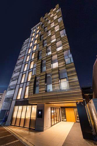 a tall building with a lot of windows at HOTEL AMANEK Kyoto Kawaramachi Gojo in Kyoto