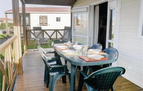 - une table sur l'arrière d'une terrasse couverte avec des chaises dans l'établissement Nice Home In Grandcamp Maisy With Wifi, à Grandcamp-Maisy