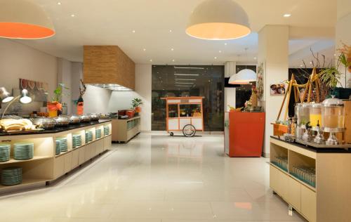 a large kitchen with a counter and a food court at HARRIS Hotel and Conventions Denpasar Bali in Denpasar