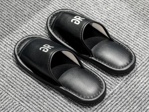 a pair of black sandals sitting on a table at Green Rich Hotel Tottori Ekimae (Artificial hot spring Futamata Yunohana) in Tottori
