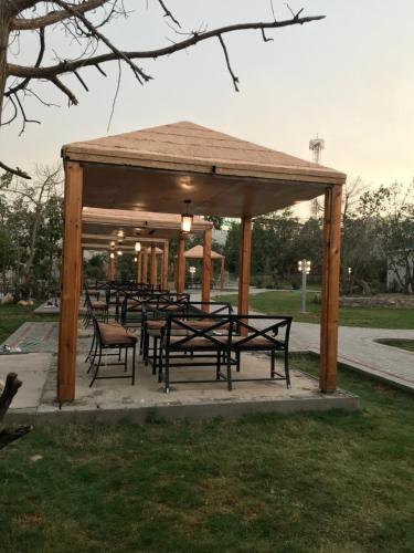 a gazebo with benches and tables in a park at Rawaat Ghaym in Taif