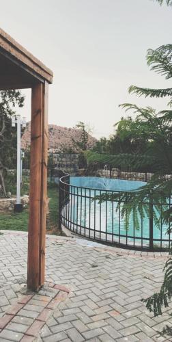 a fence next to a swimming pool in a yard at Rawaat Ghaym in Taif