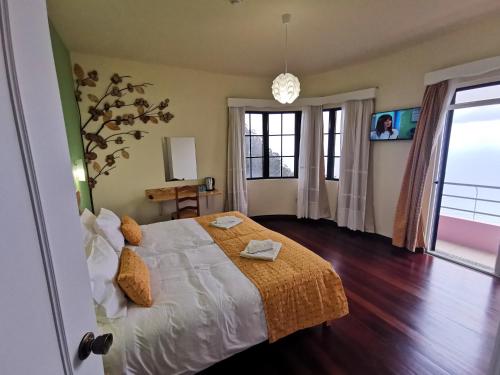 - une chambre avec un lit et une grande fenêtre dans l'établissement Santana in Nature Bed & Breakfast, à Santana