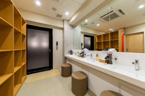 a bathroom with two sinks and a large mirror at HOTEL AMANEK Kyoto Kawaramachi Gojo in Kyoto