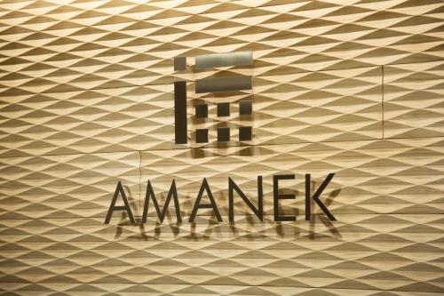 a sign on a wall with the name of a manisk at HOTEL AMANEK Kyoto Kawaramachi Gojo in Kyoto