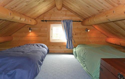 a bedroom with two beds in a log cabin at Amazing Home In Srvgen With Wifi in Sørvågen