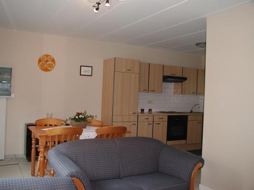 eine Küche mit einem Sofa und einem Tisch mit Stühlen in der Unterkunft De Bosbeekpoort in Opglabbeek
