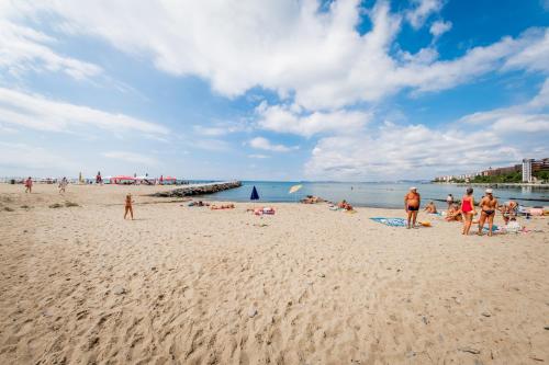 a group of people on a beach near the water at Messambria Fort Noks Beach Apartments in Elenite