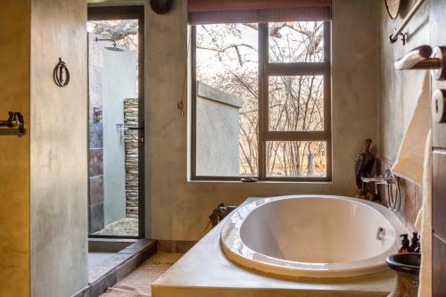 a large bath tub in a bathroom with a window at Ukuthula Bush Lodge in Hoedspruit