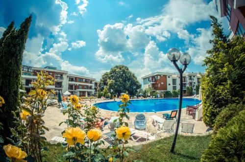 a view of a swimming pool with yellow flowers at Messambria Fort Noks Beach Apartments in Elenite