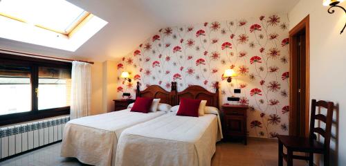 1 dormitorio con 1 cama y papel pintado con motivos florales en Lagunas de Urbión en Molinos de Duero
