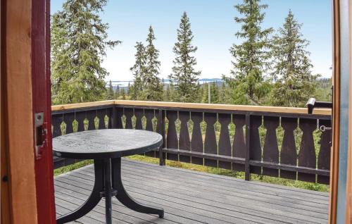 a table on the balcony of a house at Stunning Home In Sjusjøen With Kitchen in Sjusjøen