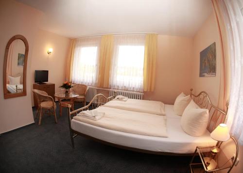 a bedroom with a large bed and a table at Hotel Bertramshof in Wismar