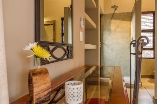 a glass table in a room with a mirror at Ukuthula Bush Lodge in Hoedspruit