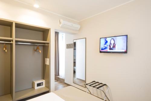 a room with a mirror and a tv on the wall at Hotel Baia di Paré in Valmadrera