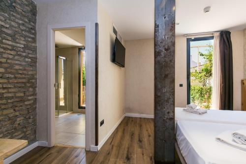 a bathroom with a white tub and a stone wall at Black Swan Hostel Sevilla in Seville