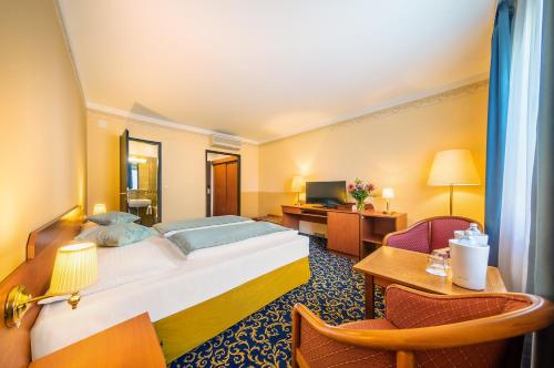 Pokój hotelowy z dużym łóżkiem i biurkiem w obiekcie Hotel Bellevue Wien w Wiedniu