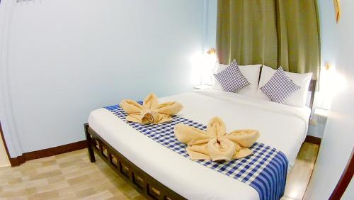 a bedroom with a bed with two flowers on it at Mango House in Sukhothai