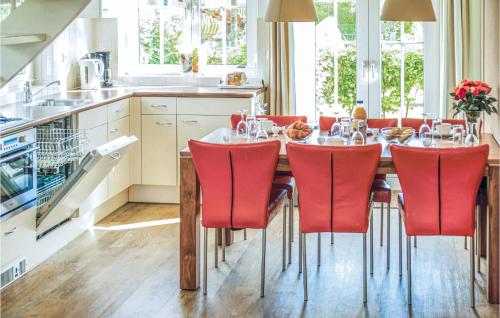 a kitchen with a dining table with red chairs at Tulp En Zee 6 Persoons in Noordwijk aan Zee