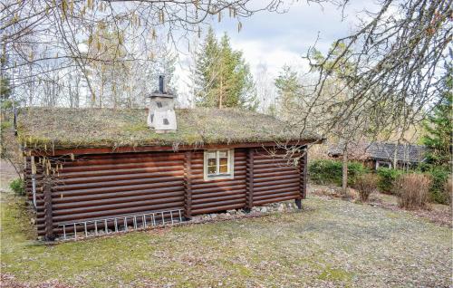 a log cabin with a grass roof with a chimney at Two-Bedroom Holiday Home In Hogsby in Högsby