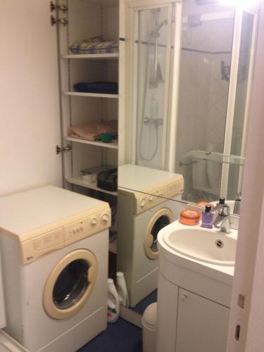a bathroom with a washing machine and a sink at Coquet studio Porte d'Auteuil - très proche de Roland Garros - durée minimum 7 nuits - parking facile à proximité in Paris