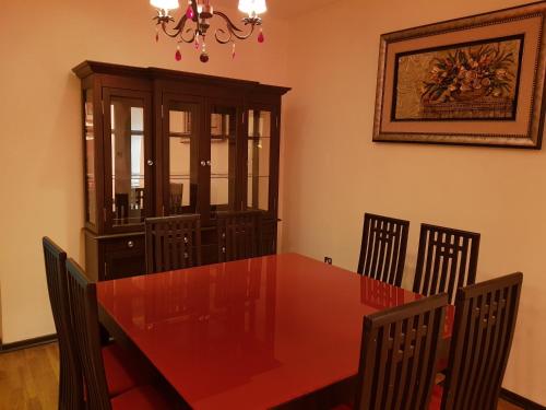 a dining room with a red table and chairs at Al Jazeera Hotel Apartments LLC in Dubai