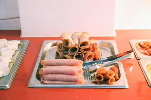 a tray of hot dogs and other food on a table at Athens Starlight Hotel in Athens