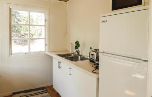 a white kitchen with a sink and a refrigerator at Four-Bedroom Holiday Home In Trosa in Trosa