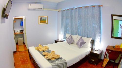 a bedroom with a bed with bows on it at Mango House in Sukhothai